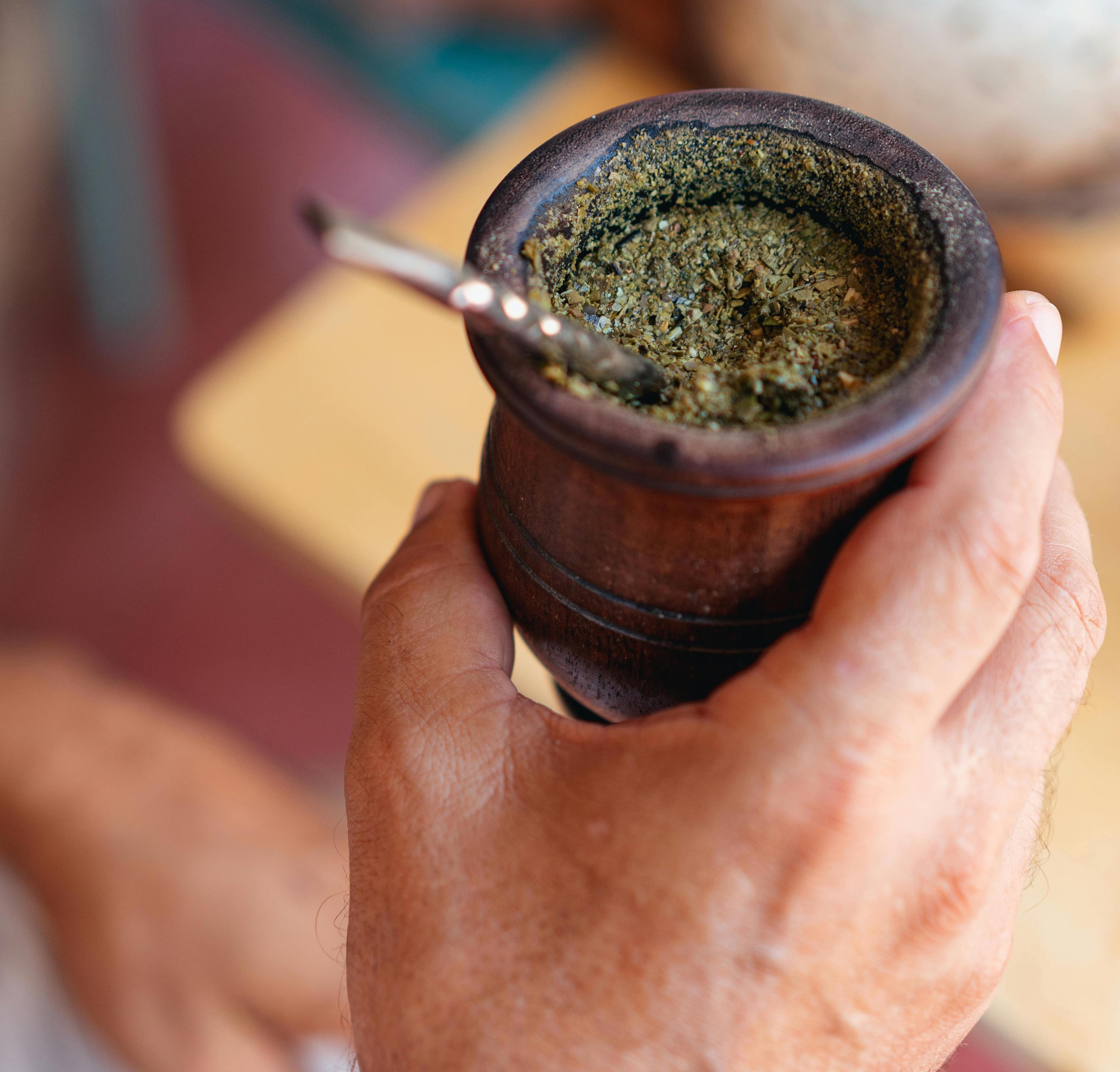 Close-up of traditional yerba mate gourd with bombilla and yerba leaves